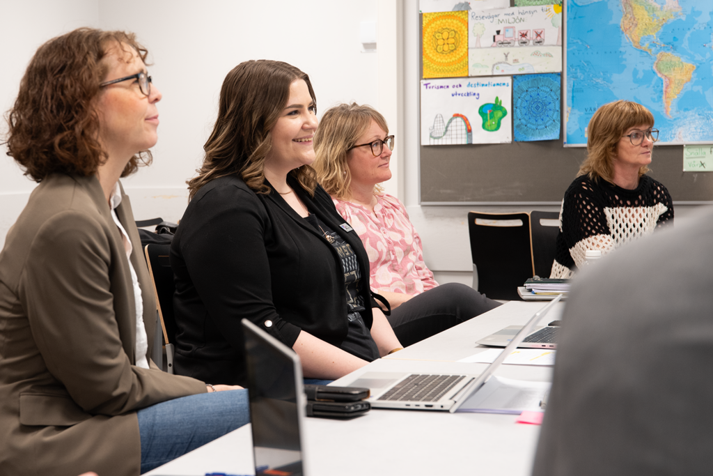 Fyra kvinnliga pedagoger i olika åldrar syns i bild sittandes i ett ljust klassrum med uppmärksamheten riktad framåt mot någon som pratar. De är koncentrerade och leende.