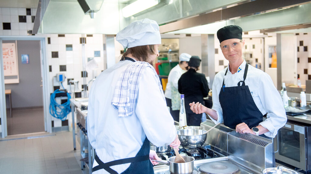 Bild. Lärare och studerande i köket på restaurangutbildning.