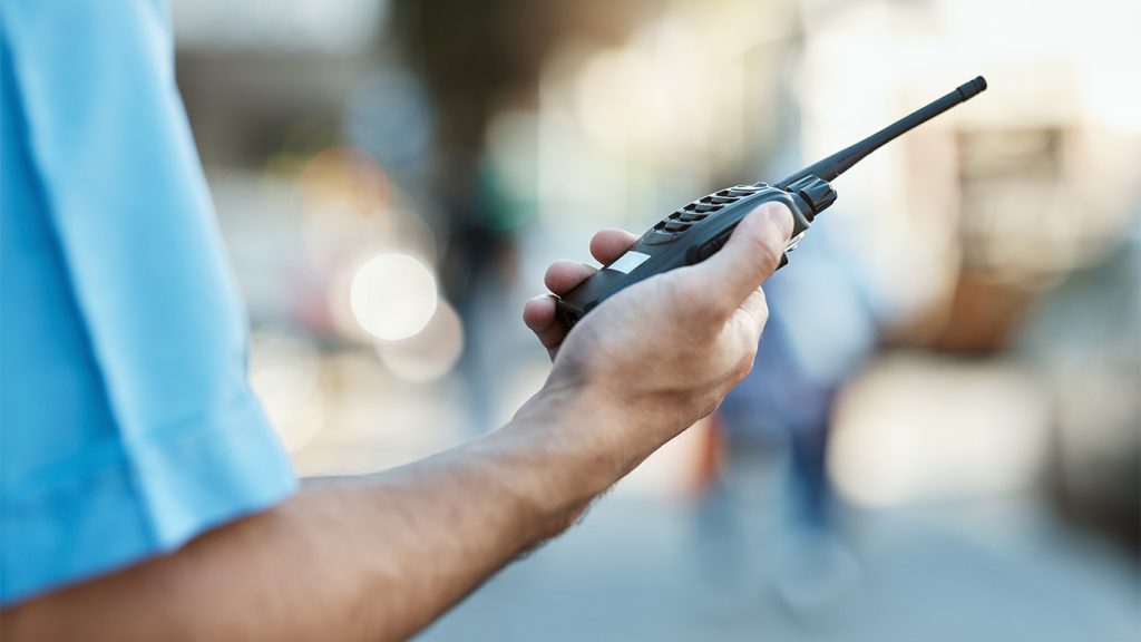 Bild. hand som håller i en walkie talkie.