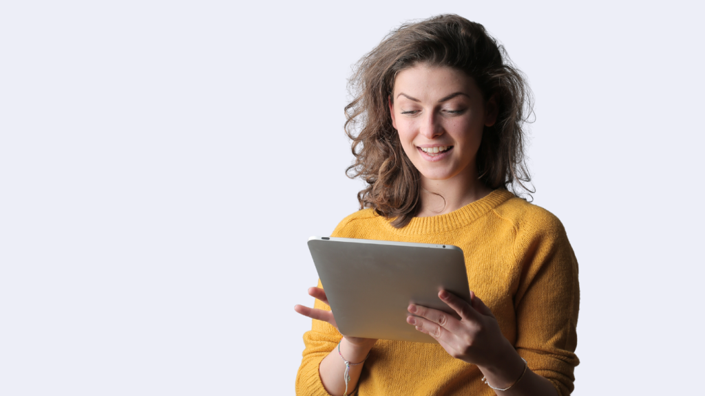 kvinna i gul tröja läser från en ipad